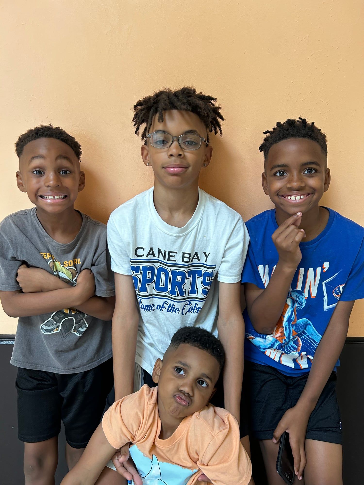 Four boys grinning and making faces for the camera